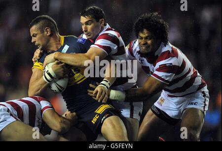 Ian Kirke von Leeds Rhinos wird von Matty Smith (Mitte) von Wigan Warriors und Epalahame Lauaki (rechts) während des Qualifying Semifinals im DW Stadium, Wigan, angegangen. Stockfoto