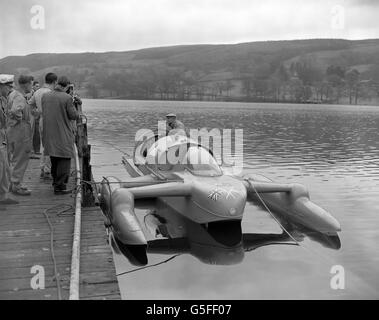 Donald Campbells Jet-Engine 'Bluebird' am Steg bei Coniston Water im Lake District, wo sie für Campbells neuen Versuch auf seinen eigenen Weltrekord im Wasser vorbereitet wurde. Im Cockpit steht Leo Villa, Chefingenieur von Donald Campbell. Stockfoto