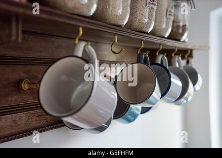 Kaffeetassen an Haken hängen Stockfoto