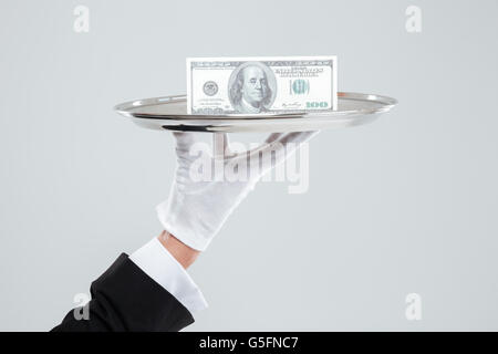 Hand der Kellner in weißen Handschuh hält Tablett mit Dollar Stockfoto