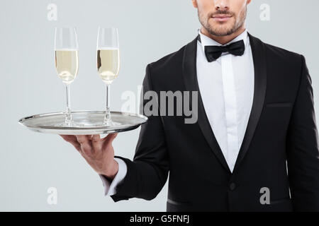 Nahaufnahme von zwei Gläser Champagner auf Tablett holded von hübschen Kellner im Smoking Stockfoto