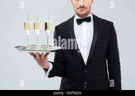 Nahaufnahme der Kellner im Smoking und Fliege hält Tablett mit Gläsern Champagner Stockfoto