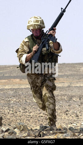 Ein Royal Marine von der Brigade Recce Force rennt in eine neue Feuerposition, während er sein M16 Sturmgewehr während einer Live-Schussübung in der omanischen Wüste umlädt. *... 45 Commando Royal Marines wurde 1943 aus dem 5. RM Bataillon gegründet und befindet sich derzeit in einer ehemaligen Royal Naval Air Station Condor Barracks westlich von Arbroath in Schottland. Rund 20,000 britische Servicekräfte - darunter die Berg- und Winterkriegstruppen der Royal Marines' 3 Commando Brigade - arbeiten mit den Royal Omani Armees bei der Übung Saif Sareea II zusammen, wie Verteidigungsminister Geoff Hoon es suchte Stockfoto