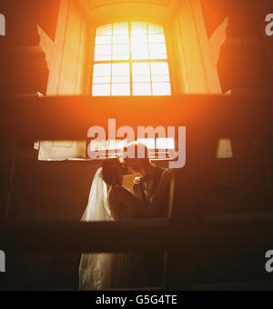 Braut und Bräutigam auf dem Hintergrund eines Fensters. Stockfoto