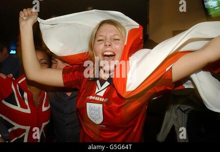 England-Fans feiern das Endergebnis von 2:2, während ihres WM-Qualifikationsspiel gegen Griechenland im Old Trafford, im Sports Cafe, Haymarket, London, was bedeutet, automatische Qualifikation für England in die WM-Finale 2002. Stockfoto