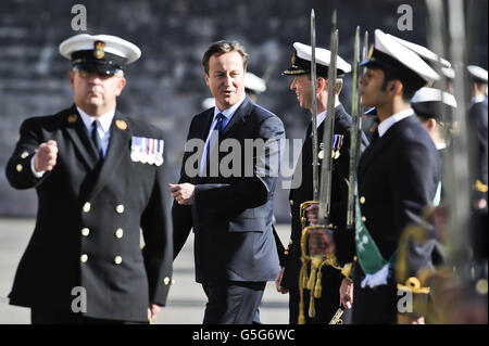 Premierminister David Cameron sieht die Marineinfanatiker während einer Passierparade im Britannia Royal Naval College in Dartmouth, wo er den Gruß nahm. Stockfoto