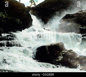 Wasserfall Bei Merok. Wasserfälle in der Nähe von Merok. Natur, Landschaft, Wasserfall, schmelzen, Wasser, Berge, Felsen, Felsen, Europa, Norwegen, Skandinavien, Reisen, Geschichte, historisch, 1910er Jahre, 1920er-Jahre des 20. Jahrhunderts, archivieren, Carl Simon, Hand-farbigen Glas-Folie Stockfoto