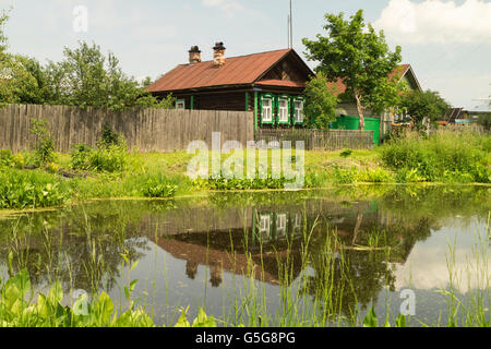 Jahres ländlichen Landschaft mit See und Holzhaus auf Hintergrund blauer Himmel Stockfoto