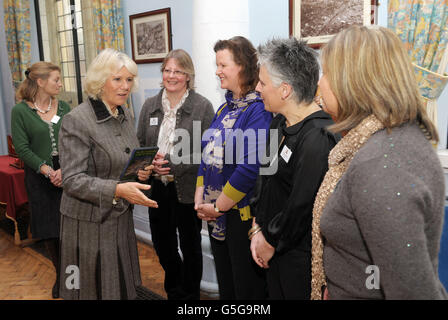 Die Herzogin von Cornwall begrüßt die Künstler, die ein Mosaik von Marlborough Tiles zum Gedenken an das Diamond Jubilee (von links nach rechts), Helen Whitfield, Val Byatt, Jenny McShane und Kirsty Robinson, während eines Besuchs im Rathaus von Marlborough kreierten. DRÜCKEN SIE ASSOCIAITON Photo. Bilddatum: Freitag, 19. Oktober 2012. Die Herzogin trägt eine DVD mit dem jüngsten Besuch des Prinzen von Wales in der Stadt. Bildnachweis sollte lauten: Tim Ireland/PA Wire Stockfoto