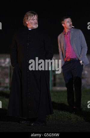 Brendan Gleeson (links) und Aidan Gillen am Set des neuen irischen Films "Calvary" in Rush Co.Dublin, als Hunderte von Einheimischen herauskamen, um zu sehen, wie eine Scheinkirche im Dorf niedergebrannt wurde. Stockfoto