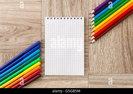 Viele Filzstifte in verschiedenen Farben und Stifte mit Notizblock, auf Holz Textur Stockfoto
