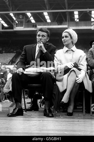 Elizabeth Taylor und Richard Burton sind die Stars des Films 'Cleopatra', an der Ringseite in Wembley, London, für das schwere Match zwischen Henry Cooper und Cassius Clay. Stockfoto