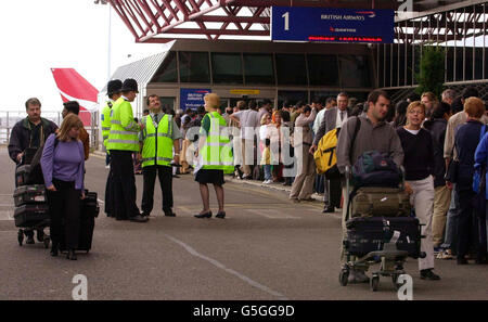 Polizei und Bodenpersonal warten darauf, dass Passagiere vor einem überfüllten Terminal 4 am Flughafen Heathrow anstehen, nachdem sie nach Terroranschlägen in New York und Washington DC storniert und verspätet sind. Stockfoto