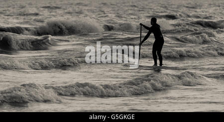 Ein Mann geht am Strand entlang am 20. Juni 2016 - Sommer-Sonnenwende - nach dem Genuss der Extras wenig Tageslicht. Stockfoto