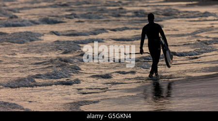 Ein Mann geht am Strand entlang am 20. Juni 2016 - Sommer-Sonnenwende - nach dem Genuss der Extras wenig Tageslicht. Stockfoto