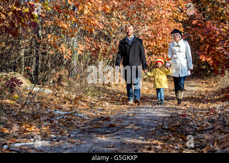 Zwei-Generationen-Familie Wandern im herbstlichen Wald-Vorderansicht Stockfoto