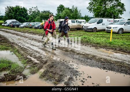 Leute kommen und Park in schlammigen und aufgeweichten Felder beim Glastonbury Festival am Standort würdig Farm, Somerset, wo schwere Regen über einen längeren Zeitraum verursacht hat isoliert Überschwemmungen und schlammige Feldern. Stockfoto