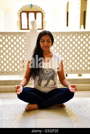 Schöne Frau mit üppigen Schlösser Schneidersitz auf Boden sitzend in der intensiven Meditation zu tiefen spirituellen Erfahrungen verbunden. Stockfoto