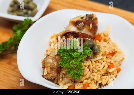 Pilaf mit Huhn, garniert mit Kapern und Petersilie Stockfoto