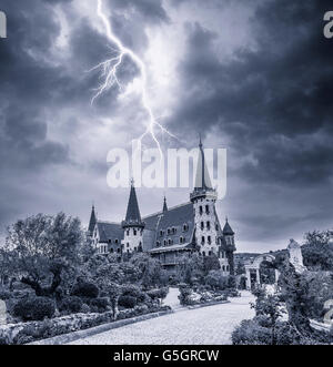 Alte steinerne Burg und Blitz in den dunklen Himmel. Stockfoto