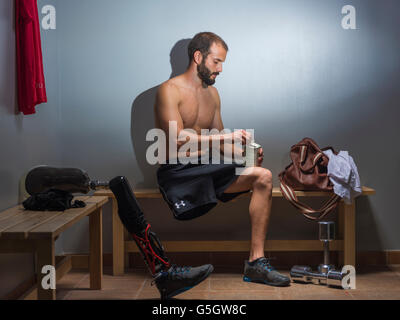 Mann mit einer Prothese in der Umkleide der Turnhalle. Stockfoto