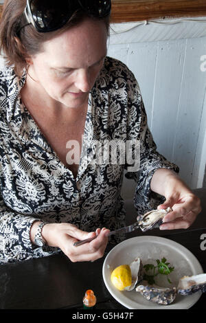 Frau frisch Walvis Bay in Namibia Austern essen Stockfoto