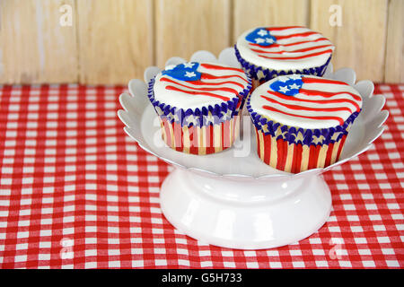 Amerikanische Flaggendesign auf patriotische Cupcake auf weißen Sockel Teller. Stockfoto