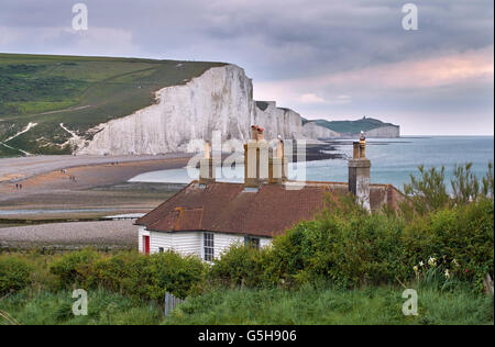 Coastguard Cottages im Seaford Kopf über dem Cuckmere River, mit den sieben Schwestern darüber hinaus. Sussex, England. Stockfoto