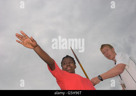 Sportlehrer angewiesen eine Schülerin mit dem Speer. England. UK Stockfoto