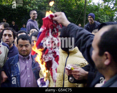 Muslimische Demonstranten verbrennen bei einer Demonstration gegen die von den USA angeführten Bombardierungen Afghanistans vor der Londoner Central Mosque des Regent Park in London eine amerikanische Flagge. * ..... Die Demonstration, an der bis zu 125 Muslime teilgenommen haben, folgte auf die Mittagsgebete, die friedlich vergingen und mehr als tausend gezählt hatten. Stockfoto