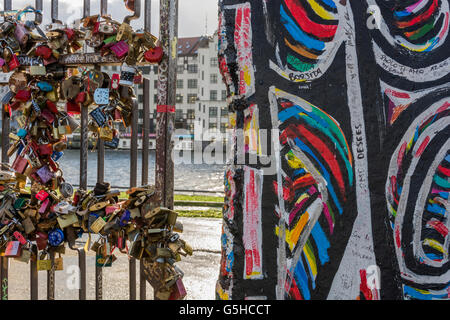 Abschnitte der Berliner Mauer, nun bedeckt mit Straßenkunst und Lovelocks in der East Side Gallery in Berlin, Deutschland Stockfoto