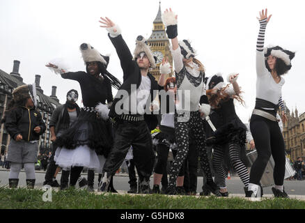 Delila Clelia 6, (links) sieht sich an, als die Tanzgruppe Artful Badger (von links nach rechts) Nwando Eebizi, Andy Black, Kirsty Mullahy, Catheirne Bell, Emma Fisher und Georgiana Cavendish vor dem Londoner Parlamentsgebäude auftreten, um gegen die Pläne der Regierung zu protestieren, Tausende der britischen Dachse zu keulen. Stockfoto