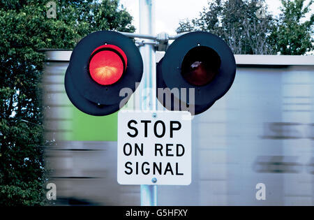 Zug vorbei blinken Warnleuchten am Bahnübergang zu beschleunigen Stockfoto