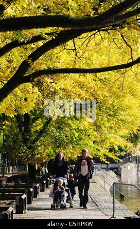 Die Menschen laufen unter einem Baumkronen aus Herbstblättern entlang des Flusses Ouse in York. Stockfoto
