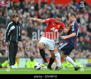 Charlie Adam von Stoke City (rechts) und Robin van Persie von Manchester United (Mitte) kämpfen um den Ball, während Stoke City Manager Tony Pulis von der Touchline aus auf den Ball schaut Stockfoto