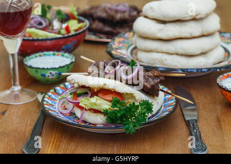 Fleisch-Spieße mit Kräutern, Limetten und Pita Brot. Stockfoto