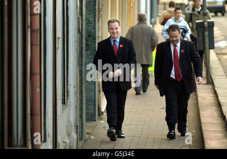 Gerüchten zufolge geht der schottische First-Minister-Anwärter Jack McConnell (L) in Begleitung des Westminster-Abgeordneten für seinen Wahlkreis Frank Roy die Hauptstraße in seinem Wahlkreis Wishaw in Schottland hinauf. *... Bildungsminister McConnell gilt als klarer Favorit, der die Nachfolge von Herrn McLeish antritt, der gestern nach Kontroversen über die Bürokosten seines Wahlkreises abgeschlagen hat. Stockfoto