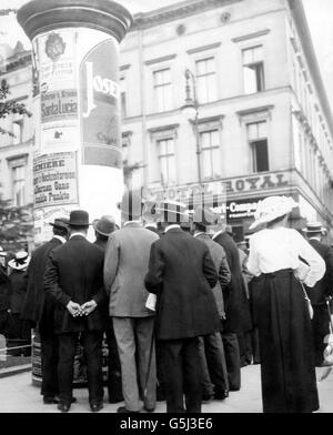 Fußgänger lesen Kriegsnachrichten auf der unter den Linden in Berlin. Stockfoto