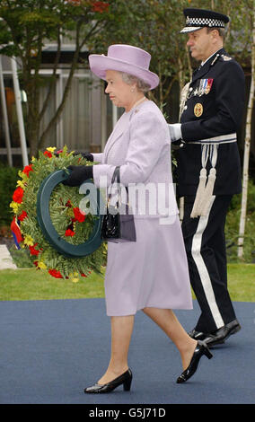 Die britische Königin Elizabeth II. Legt in Begleitung des Kommissars für die Metropolitan Police, Sir John Stevens, einen Kranz ab, nachdem sie eine Gedenktafel für die im Dienst getöteten Offiziere in den Gärten des Polizeitrainingshauptquartiers in Hendon im Norden Londons enthüllt hat. *...Sie sagte, dass die Terroranschläge in Amerika eine deutliche Erinnerung an die Schuldengesellschaft seien, die der Polizei und anderen Notdiensten geschuldet sei, und dass diejenigen, die das ultimative Opfer darbrachten, nie vergessen werden sollten. Stockfoto