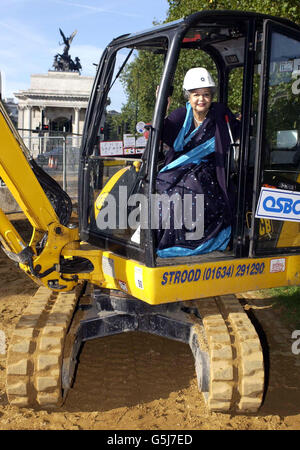 Baroness Flather, Vorsitzende des Memorial Gates Trust, in einem Bagger, der zu Beginn des Baus der zeremoniellen Tore auf dem Constitution Hill in London für einen feierlichen Spatenstich verwendet wurde. * die Tore werden der Rolle von fünf Millionen Männern und Frauen aus dem indischen Subkontinent, Afrika und der Karibik gedenken, die während der beiden Weltkriege als Freiwillige bei den britischen Streitkräften tätig waren. Stockfoto