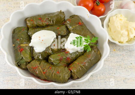 Sarma rollt in einer Platte bedeckt mit Gewürzen und Sauerrahm Stockfoto