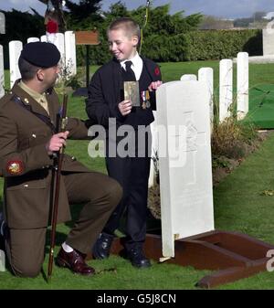 Jay Wilkinson, 9, der Ur-Ur-Enkel des privaten Harry Wilkinson, mit Sgt Major Hayden Aldred, blickt auf den Grabstein seiner Verwandten, nachdem der Soldat im Ersten Weltkrieg schließlich auf dem Prowes Point Friedhof in Belgien zur Ruhe gelegt wurde. * Wilkinson, 29, aus Bury, Lancashire des 2. Bataillons Lancashire Fusiliers, wurde am 10. November 1914 auf einem Feld in Belgien getötet. Seine Überreste mit seinem Identitätsschild und seinem und Lancashire Fusiliers Mützenabzeichen wurden erst 87 Jahre später, im Januar 2000, auf dem Feld bei Ploegsteert Wood gefunden. Stockfoto