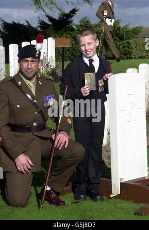 Jay Wilkinson, 9, der Ur-Ur-Enkel des privaten Harry Wilkinson, mit Sgt Major Hayden Aldred, blickt auf den Grabstein seiner Verwandten, nachdem der Soldat im Ersten Weltkrieg schließlich auf dem Prowes Point Friedhof in Belgien zur Ruhe gelegt wurde. * Wilkinson, 29, aus Bury, Lancashire des 2. Bataillons Lancashire Fusiliers, wurde am 10. November 1914 auf einem Feld in Belgien getötet. Seine Überreste mit seinem Identitätsschild und seinem und Lancashire Fusiliers Mützenabzeichen wurden erst 87 Jahre später, im Januar 2000, auf dem Feld bei Ploegsteert Wood gefunden. Stockfoto