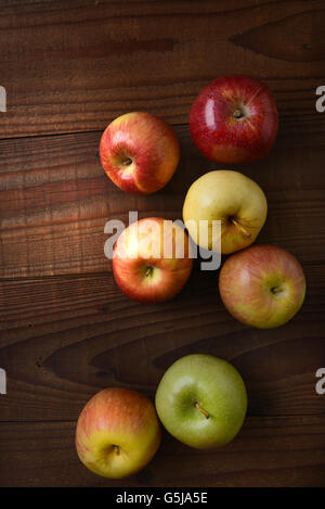 Verschiedene Sorten von frisch gepflückten Äpfel auf einem rustikalen Holztisch. Fuji, Gala, Granny Smith, Braeburn, Golden Delicious geschossen her Stockfoto