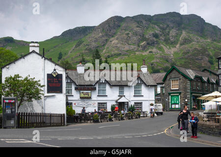 Black Bull Hotel und Dorfladen mit Fells Coniston Cumbria England UK mit dunklen Regenwolken Stockfoto