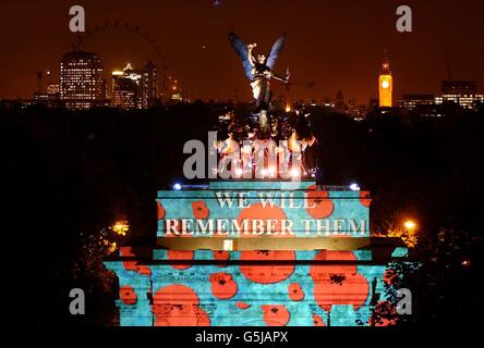 Mohnblumen blühen am Wellington Arch im Londoner Hyde Park. Vor dem Gedenktag wird Wellington Arch mit fallenden Mohnblumen beleuchtet, um den 80. Jahrestag des Mohn-Appells der Royal British Legion zu feiern. *...eines der berühmten Wahrzeichen Londons, Wellington Arch, wird eine spektakuläre Kulisse für die lebhaften roten Mohnblumen und die Botschaft "Wir werden sie erinnern" bieten, die jeden Abend von Dienstag, 6. November bis Samstag, 10. November 2001 auf das Denkmal projiziert wird. Stockfoto