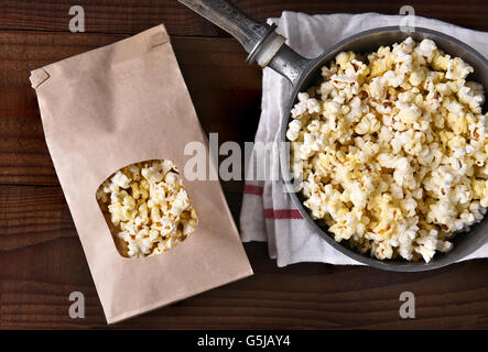 Draufsicht auf einen Beutel mit Gourmet-Popcorn neben einen Topf mit frisch knallte Mais. Stockfoto