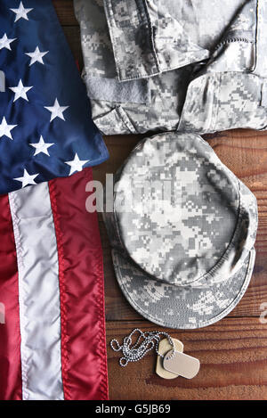 Draufsicht der militärischen Strapazen, Erkennungsmarken und amerikanische Flagge auf einem hölzernen Hintergrund. Militärischer Service-Konzept für Memorial Day, Weter Stockfoto