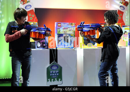 Harry Ashley, 12, (L), und Caius Duncombe, 13, (R) Spielen Sie mit dem Nerf N Strike Elite Spielzeug auf der Ausstellung Dream Toys der Toy Retailers Association in der St. Mary's Church, Wyndham Place, London. Stockfoto