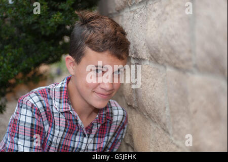 Moderne weibliche Teenager mit Bürstenschnitt stellte neben der Mauer. Stockfoto